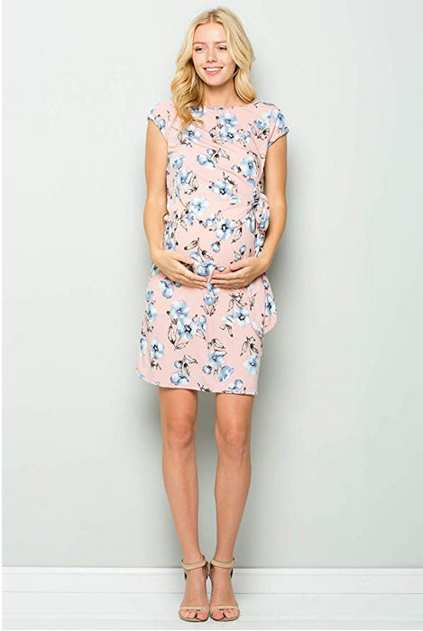 Pregnant woman in a pink floral side-tie maternity dress